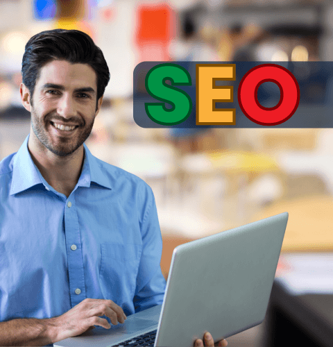 Man smiling while using a laptop with colourful 'SEO' text in the background.